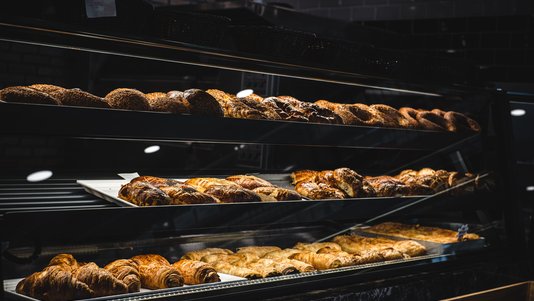 pastries and croissants in glass bakery display case