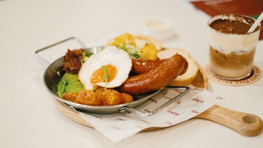breakfast plate with sausages fried egg and coffee at cafe