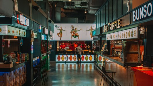 indoor food court with multiple food stalls and shared counters