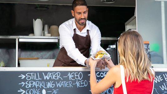 woman buying burger at food truck counter