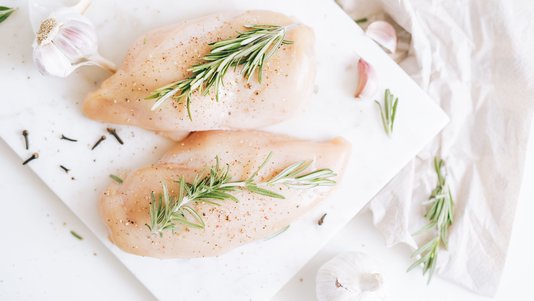 raw chicken breast seasoned with herbs ready for marinating